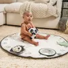 A baby is sitting on a playmat with toys. Produktbild-Vorschau