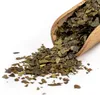 A wooden scoop filled with dried leaves, with some leaves spilled onto a white surface. Náhled obrázku produktu