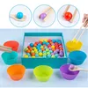A Montessori learning set for children, featuring colorful sorting balls and cups, along with tools for manipulation. Produktbild-Vorschau