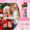 Two young girls are happily interacting with a gift in front of a Christmas tree, with a pink toy keyboard and gift boxes in the background. Produktbild-Vorschau