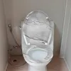 A toilet with a marble-patterned seat and lid in a bathroom. Produktbild-Vorschau