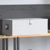 A silver aluminum storage box with a diamond plate pattern sits on a wooden shelf against a gray pegboard wall. Náhled obrázku produktu