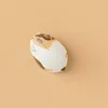 A computer mouse designed to look like a calico cat, placed on a plain light orange background. Anteprima dell’immagine prodotto
