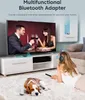 A woman is lying on a rug, wearing headphones and holding a remote, while a dog sleeps nearby. A TV is on in the background, displaying a couple toasting. Produktbild-Vorschau