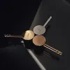 Three vanity faucets in different metallic finishes (gold, silver, rose gold) arranged on a reflective black surface with dramatic lighting. Podgląd zdjęcia produktu