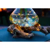 A glass vase with water and lights on a piece of driftwood. Produktbild-Vorschau