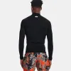 A man wearing a black long-sleeved shirt and patterned shorts, viewed from the back. Produktbild-Vorschau