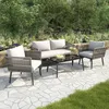 A four-piece outdoor furniture set on a stone patio surrounded by greenery. Podgląd zdjęcia produktu