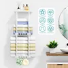 A white towel rack mounted on a wall, filled with folded towels. Decorative items and a plant are also visible. Produktbild-Vorschau