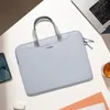 A light blue laptop bag is placed on a white surface next to a laptop, a smartphone, and a pair of wireless earbuds. Náhľad obrázku produktu