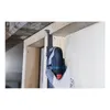 A person wearing a glove is using a Bosch oscillating multi-tool to cut into a wooden frame near a wall. Produktbild-Vorschau