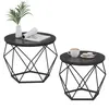 Two round coffee tables with geometric metal bases and dark wood tops, one set with a plant and book, the other with a coffee cup and macarons. Podgląd zdjęcia produktu