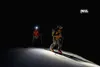 Two skiers with headlamps hiking up a snowy slope at night. Náhled obrázku produktu