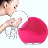 Leuchtend rosa Silikon-Gesichtsreinigungsbürste neben einer Frau, die sich Wasser ins Gesicht spritzt, mit vergrößerter Ansicht ihrer Hände Anteprima dell’immagine prodotto