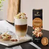 A glass of coffee with whipped cream and toppings, next to a box of coffee capsules. Náhľad obrázku produktu