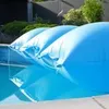 Three blue inflatable pool air cushions float on the surface of a swimming pool. Produktbild-Vorschau