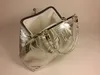 A silver clutch purse with a floral pattern is shown against a light gray background. Podgląd zdjęcia produktu