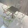 A square table with four chairs around it, in different colors. Anteprima dell’immagine prodotto