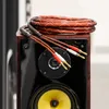 A close-up shot of speaker cables resting on top of a speaker. Podgląd zdjęcia produktu
