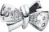 A close-up studio shot of a silver bow-shaped charm with small clear stones. Podgląd zdjęcia produktu