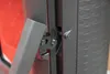 A close-up view of a hinge mechanism on a red object, possibly a stove or fireplace, with a textured black surface. Náhľad obrázku produktu