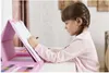 A young girl is drawing at a table with an art set. Anteprima dell’immagine prodotto