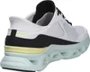 A side view of a white and black Skechers sneaker with a mint green sole. Voir les images du produit