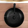 A black marble basin with a black faucet on a wooden surface. Anteprima dell’immagine prodotto