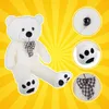 A large white teddy bear is shown against a yellow sunburst background, with close-up insets of its eye, paw, and bow tie. Anteprima dell’immagine prodotto