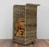 A wicker log basket filled with firewood, placed on a wooden floor against a white wall. Produktbild-Vorschau
