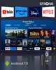 A television displaying various streaming service logos and content, with a streaming stick and remote in the foreground. Náhled obrázku produktu