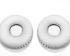 Two white circular ear pads are shown against a white background. Náhled obrázku produktu