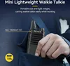 A person's hand is holding a walkie-talkie that is partially tucked into a pocket. Voir les images du produit