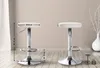 Two white bar stools are shown in a room with wooden flooring and a neutral wall. Dimensions are indicated with lines and text. Podgląd zdjęcia produktu