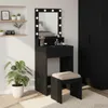 A black vanity table with a lighted mirror and a stool in a room. Voir les images du produit