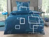 A bed with blue bedding featuring a geometric pattern. Produktbild-Vorschau