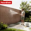 A man is cleaning a fence with a hose in a garden setting. Produktbild-Vorschau