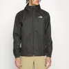 A person wearing a black jacket and tan pants against a white background. Produktbild-Vorschau