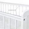 A close-up view of the white railing of a baby crib, with a label indicating 'inkl. Beißschienen' (including teething rails). Produktbild-Vorschau