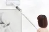 A woman is using a spray mop to clean a wall next to a framed picture of a horse. Podgląd zdjęcia produktu