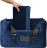 A hand is placing a cushion into a blue velvet dog car seat. Produktbild-Vorschau