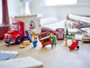 LEGO minifigures are moving a piano into a truck, with other furniture and a trumpet in the background. Náhľad obrázku produktu