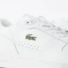 A close-up view of a white Lacoste sneaker with the iconic green crocodile logo. Náhľad obrázku produktu