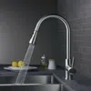 A kitchen faucet with water running into a sink, with lemons and bottles in the background. Náhled obrázku produktu