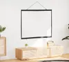 A projection screen is hanging on a white wall above a wooden cabinet. Voir les images du produit