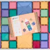 A box of Connetix Magnetic Tiles Pastel is placed on top of a larger arrangement of magnetic tiles. Podgląd zdjęcia produktu