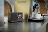A PURE Classic H4i DAB+ Internetradio sits on a kitchen counter next to a coffee machine and a candle. Voir les images du produit