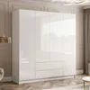 A modern, white, high-gloss wardrobe with four doors and two drawers, set in a well-lit room with a wooden floor and elegant wall paneling. Produktbild-Vorschau