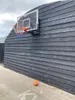 A basketball hoop mounted on a dark wooden wall with a basketball on the ground. Produktbild-Vorschau