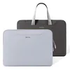 Two laptop bags are shown against a white background. One is a dark gray tote bag with handles, and the other is a light gray sleeve in front of it. Náhľad obrázku produktu